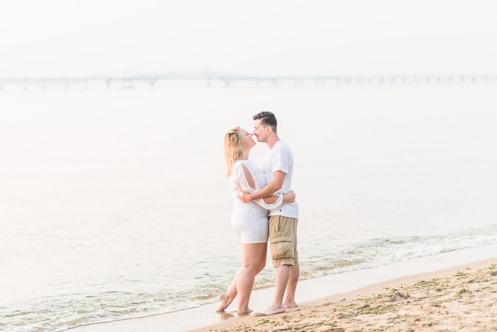 Proposal in Maryland Beach Engagement Tips. Beach with bridge in the back with couple. 