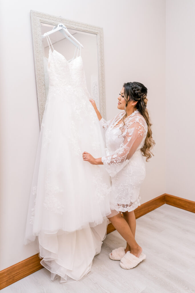Bride looking at her wedding dress before putting it on.